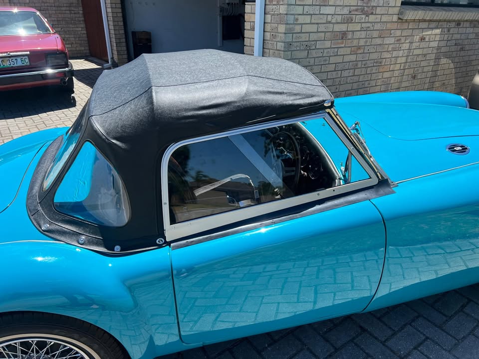 The black hood erected, showing the rear window and frame